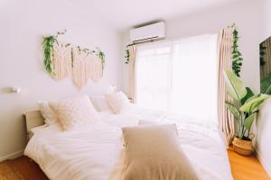 a white bed in a room with a window at Chic Nakasu Apartment Perfect for 2 Guests in Fukuoka