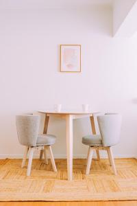 a dining room table with two chairs and a picture at Chic Nakasu Apartment Perfect for 2 Guests in Fukuoka