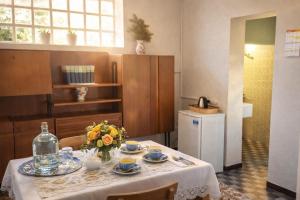 a kitchen with a table with a vase of flowers on it at Lavanda Cozy Apartment near Lake Como and Lugano in Lanzo dʼIntelvi +23 photos