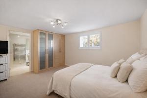 a white bedroom with a bed and a television at Randall Farm Near Brands Hatch Circuit in Fawkham