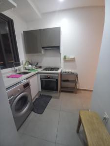 a kitchen with a stove and a washing machine at Princess Mayfer in Maarif