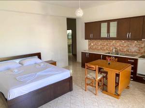 a bedroom with a bed and a table and a sink at VIOLA Seaside Villa in Ksamil