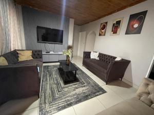 a living room with two couches and a tv at Alamaison in Umtali
