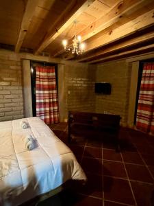 a bedroom with a bed and a bench in a room at Hotel-Posada Kali Tlayacapan in Tlayacapan