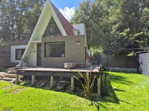 a small house with a triangular roof on a yard at Estrellita Mia in Villa Ciudad Parque