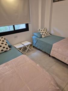 a room with two beds and a chair in it at Estrellita Mia in Villa Ciudad Parque