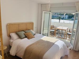 a bedroom with a large bed and a balcony at RÍA LIVING - Arena 01 in Cee
