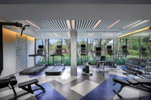 ein Fitnessstudio mit Laufbändern und Ellipsentrainern in der Unterkunft OZO Phuket in Kata Beach
