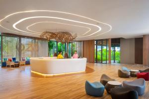 eine Lobby eines Hotels mit Rezeption und Stühlen in der Unterkunft OZO Phuket in Kata Beach + 122 Fotos