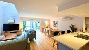 a living room with a couch and a kitchen and a table at SixtySix at Cape View in Broadwater