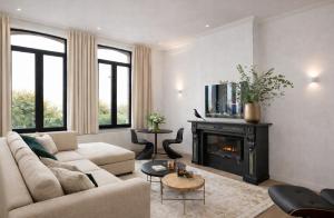 a living room with a couch and a fireplace at SLEEP INN - Kaai11, Riverview Lofts & Suites in Antwerp