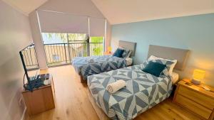 a bedroom with two beds and a balcony at SixtySix at Cape View in Broadwater +22 photos