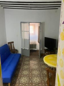 a living room with a blue couch and a table at Casona Los Infantes in Villanueva de los Infantes