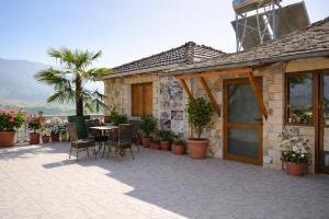 a house with a patio with a table and chairs at Guest house Memushi in Gjirokastër +7 photos