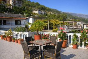a patio with a table and chairs and potted plants at Guest house Memushi in Gjirokastër