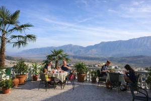 a group of people sitting at a table on a patio at Guest house Memushi in Gjirokastër