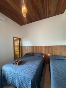 a bedroom with two beds and a purse on the bed at Flat Bluvi Centro de Barra-Grande in Marau