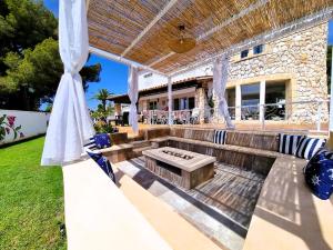an outdoor patio with a bench and a pergola at Villa Gigi Torre del Sol - 14-18 pers - Coma-Ruga in El Vendrell