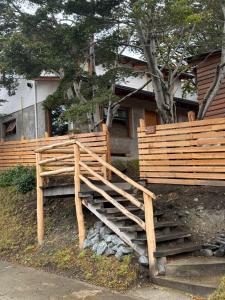 a wooden bench sitting in front of a house at Las raíces departamentos in Ushuaia