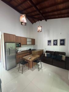 a kitchen and living room with a table and a couch at Flat Bluvi Centro de Barra-Grande in Marau