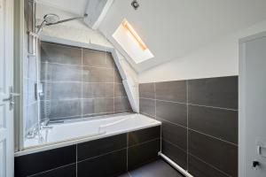 a bathroom with a bath tub and a shower at Le Bossuet - Cosy et Charme au Centre Historique in Dijon