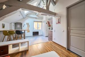 a kitchen and living room with a table and chairs at Le Bossuet - Cosy et Charme au Centre Historique in Dijon +3 photos