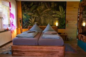 a bedroom with two beds and a painting on the wall at Pension Pulvermühle in Waischenfeld