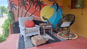 a room with two chairs and a surfboard on a wall at Costamar Galinhos in Galinhos