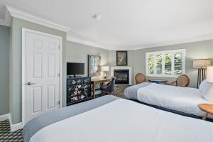 a hotel room with two beds and a desk at Cambria Pines Lodge in Cambria +119 photos