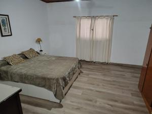 a white room with a bed and a window at Santa Fe 304 in Gualeguaychú