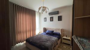 a bedroom with a bed with blue sheets and a window at Boho sokhna families only in Ain Sokhna +46 photos