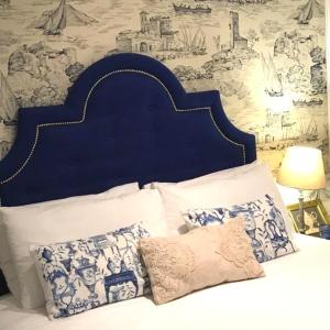 łóżko z niebieskim zagłówkiem i poduszkami w sypialni w obiekcie Your Home in Bairro Alto w Lizbonie