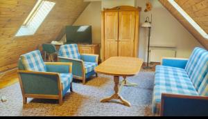 a living room with blue chairs and a table at Hotel Karkonosze in Karpacz