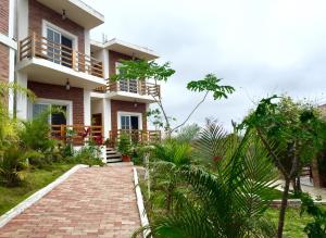 a house with a brick walkway in front of it at Muyuyo Lodge in Ayangue