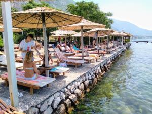 a group of people sitting on lounge chairs in the water at Apartment Deki studio 2 in Kotor