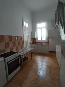 a kitchen with a stove and a table in it at comfortable room and shared kitchen and bathroom in Athens