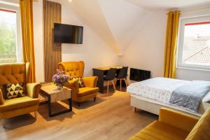 a bedroom with a bed and chairs and a table at „Amber” Pokoje z widokiem na morze in Krynica Morska