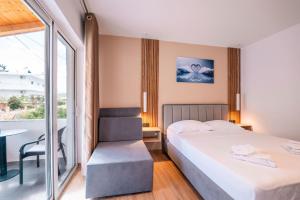 a bedroom with a bed and a table and a window at Velora Apartments Ksamil in Ksamil
