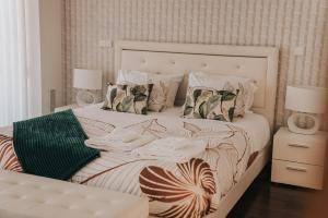 a bedroom with a white bed with pillows at Casa Moinho Vedro in Quintiães +43 photos