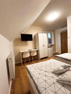 a bedroom with a bed and a desk and a tv at „Amber” Pokoje z widokiem na morze in Krynica Morska
