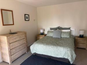 a bedroom with a bed and a dresser and a mirror at The Beach House in Red Beach