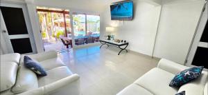 a living room with a white couch and a table at Jobos Beach House - Steps from the beach! in Isabela
