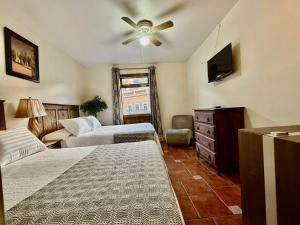 a living room with two beds and a television at San Carlo hotel in Guanajuato