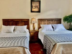 two beds sitting next to each other in a bedroom at San Carlo hotel in Guanajuato