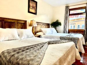 a hotel room with two beds and a window at San Carlo hotel in Guanajuato