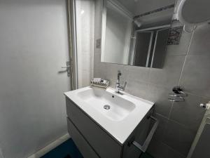a bathroom with a white sink and a mirror at Appartamento bilocale in Cecina +18 photos