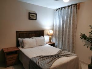 a bedroom with a bed with white sheets and a window at San Carlo hotel in Guanajuato