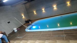 a blue tub in a bathroom with a person sitting next to it at Área de Lazer BR 267 in Bataguaçu