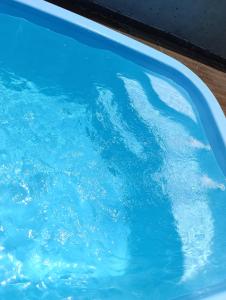a pool filled with blue water next to a table at Área de Lazer BR 267 in Bataguaçu +4 photos