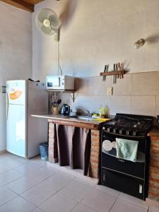 a kitchen with a stove and a refrigerator at Cabañas Tinku del Sol in Casa Grande